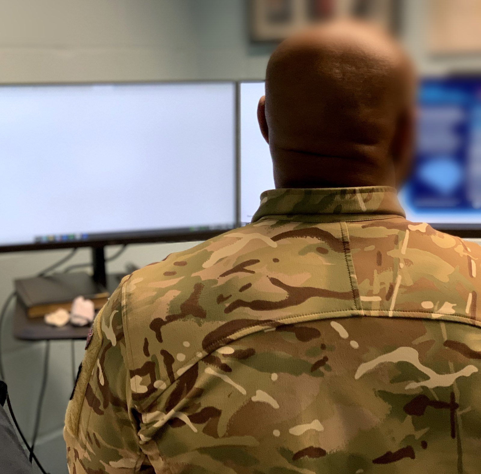 A moderated session seen from behind: a frontline user working through the prototype on screen
